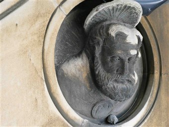 A face by the round window on the N Transept exterior